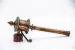 Close-up of Om Mani Padme Hum engraved on copper prayer wheel