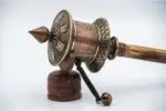 Close-up of Om Mani Padme Hum engraved on copper prayer wheel