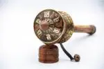 Close-up of Om Mani Padme Hum engraved on copper prayer wheel