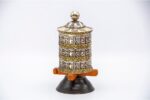 white metal tabletop prayer wheel features a triple-line Om Mani Padme Hum mantra. Handcrafted in Nepal and filled with sacred mantra scrolls.