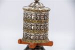 white metal tabletop prayer wheel features a triple-line Om Mani Padme Hum mantra. Handcrafted in Nepal and filled with sacred mantra scrolls.