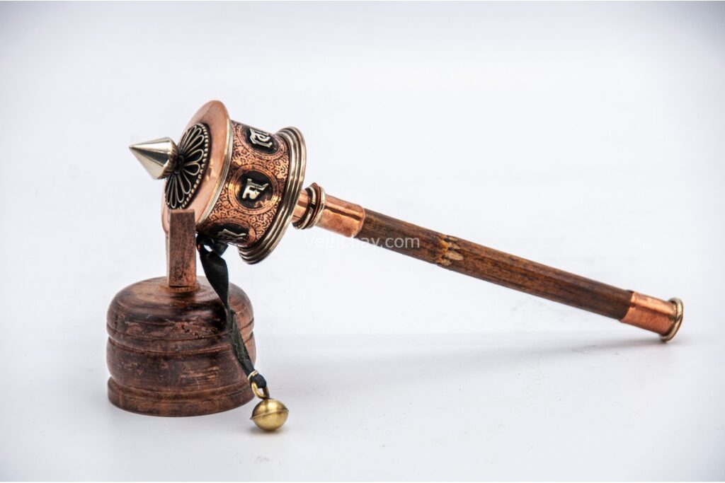 Close-up of Om Mani Padme Hum symbols on copper cylinder
