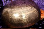 Extra large handmade singing bowl featuring Buddha Foot in center, mantra etching, and Eight Auspicious Symbols