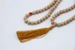 Lotus Mala with Red Coral Stone – handcrafted 108-bead prayer necklace featuring lotus accents and vibrant red coral beads, symbolizing passion, transformation, and spiritual awakening. Ideal for meditation, mantra chanting, and chakra healing.
