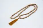 Lotus Mala with Red Coral Stone – handcrafted 108-bead prayer necklace featuring lotus accents and vibrant red coral beads, symbolizing passion, transformation, and spiritual awakening. Ideal for meditation, mantra chanting, and chakra healing.