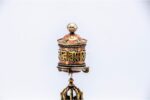 lose-up of engraved Om Mani Padme Hum mantra on Tibetan prayer wheel Bottom view of Vajra brass base on Buddhist prayer wheel Prayer wheel being held and spun – traditional dharma practice